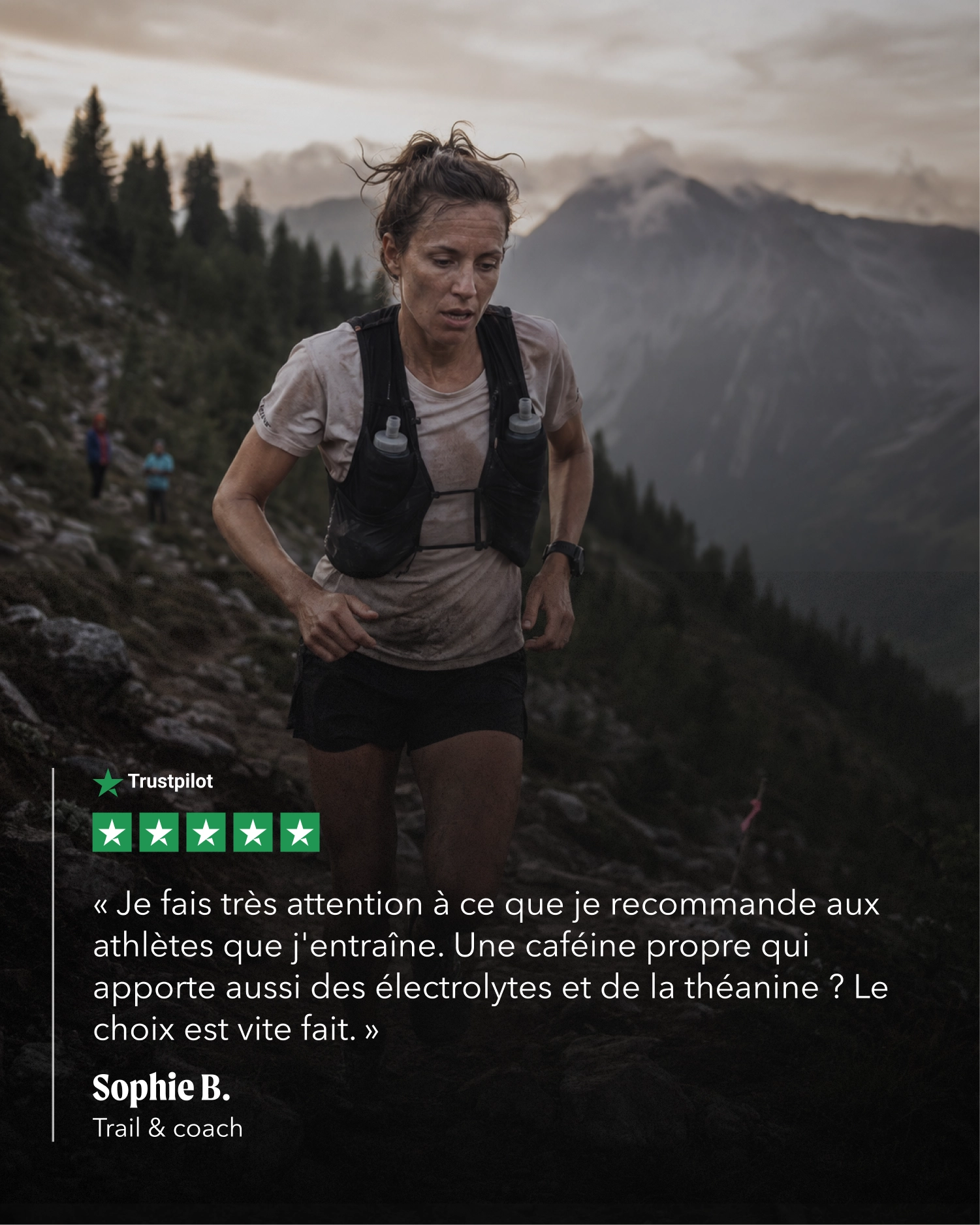 A woman trail running through a mountain landscape, wearing a light gray athletic shirt, black shorts, and a black hydration backpack. A quote overlay from Trustpilot is displayed on the left side against a dark mountain background.